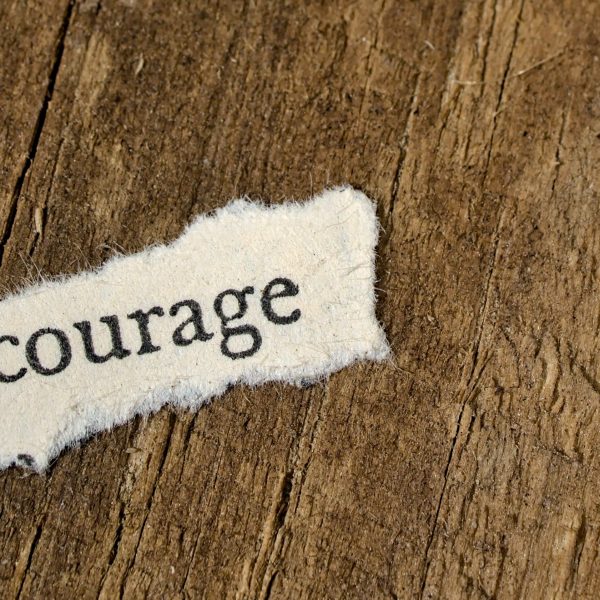 word courage on wooden background